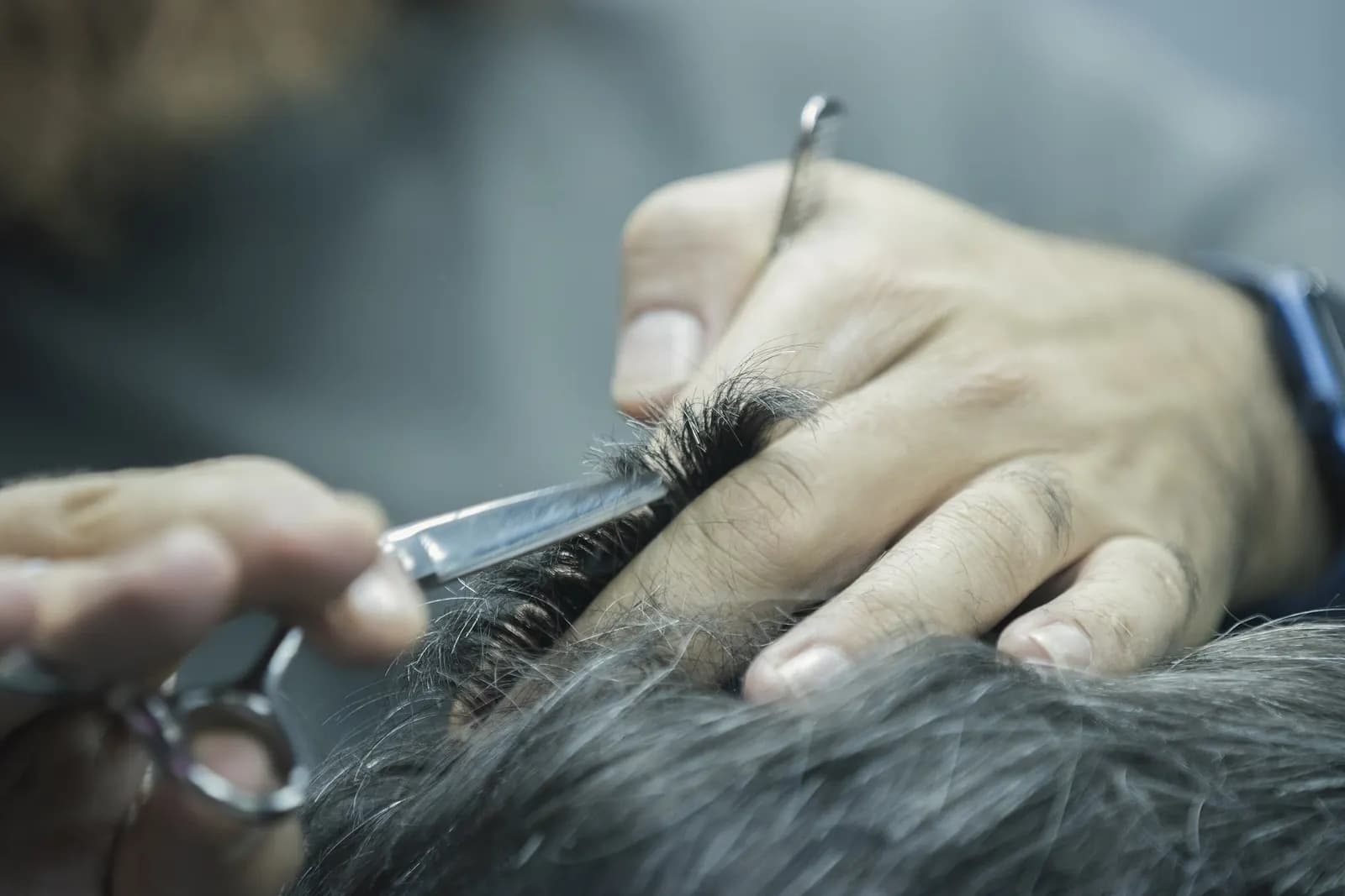 Un rasoio sfoltitore che passa fra i capelli, ripreso da vicino.